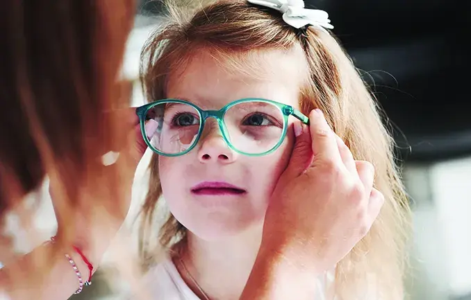 Female child being fit for glasses