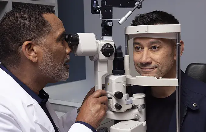Male patient receiving eye exam with optometrist. 