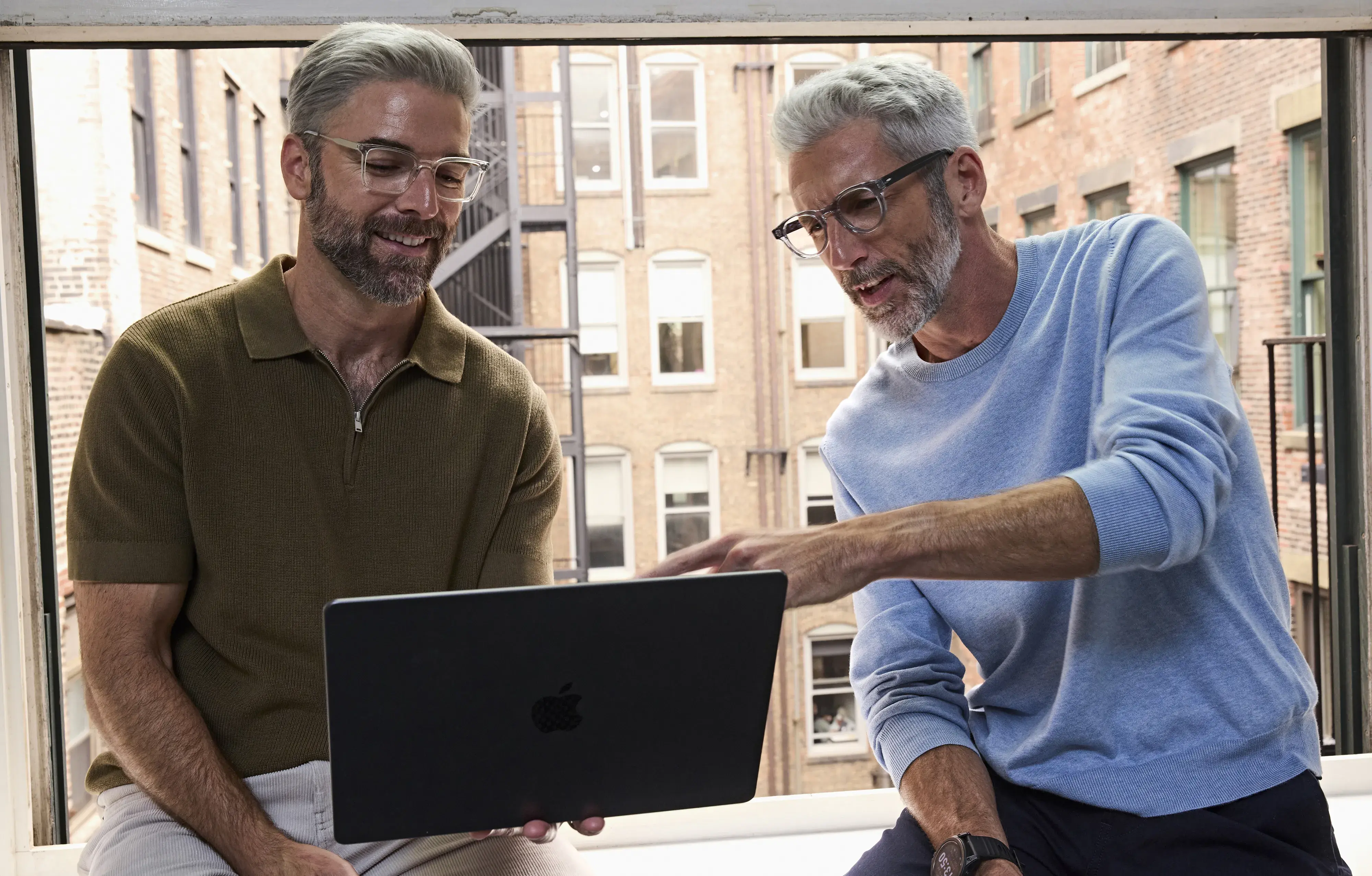 Two males wearing glasses viewing computer screen