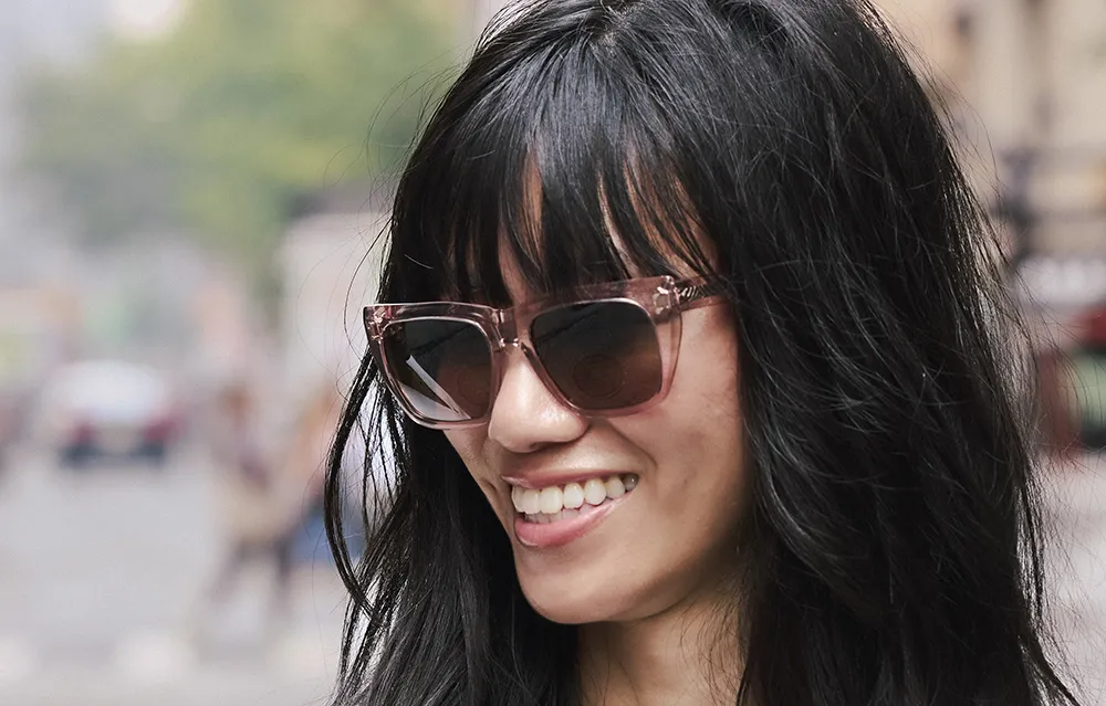 Brunette female smiling wearing Maui Jim sunglasses