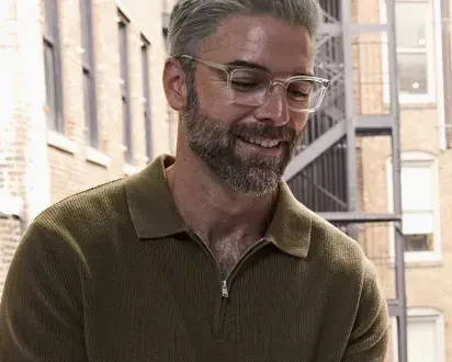Male wearing glasses in New York City apartment. 