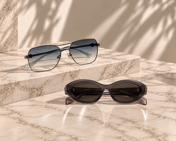 Two pair of sunglasses side by side on granite background