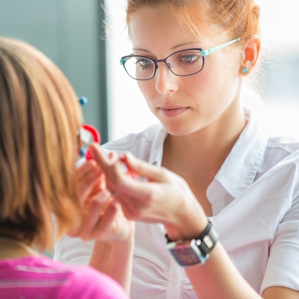 woman in glasses testing a persons eyes