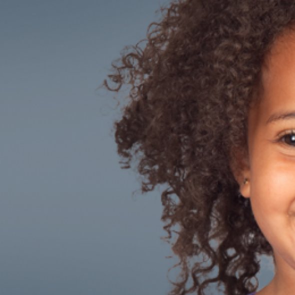 small child with curly hair smiling