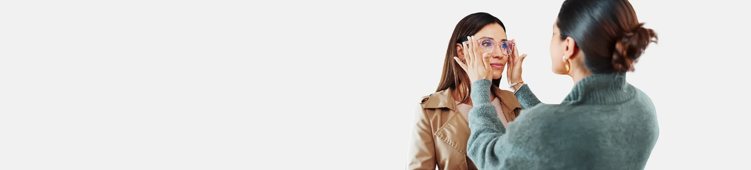 Optician putting glasses on a customer