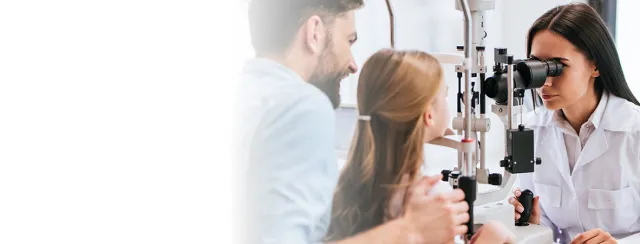 Female doctor performing eye exam on child