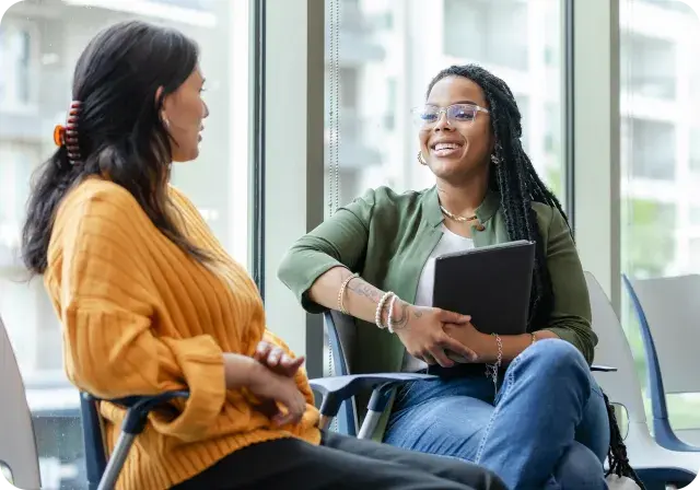 Two people talking, one wearing glasses, warm and natural.”