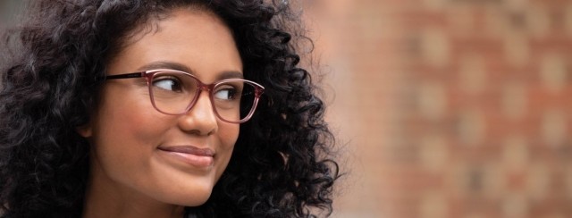 young woman with dark curly hair and glasses