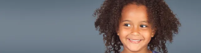 small child with curly hair smiling