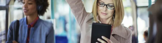 women in glasses reading tablet on bus 