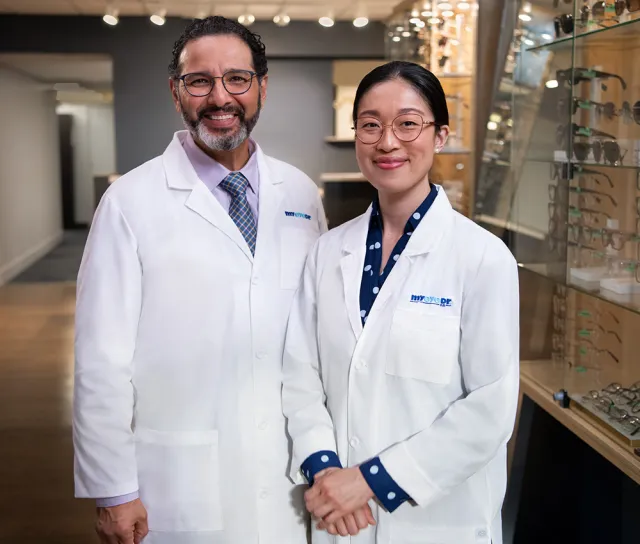 Smiling eye doctors welcoming patient