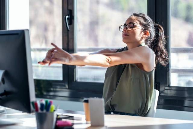 Woman stretching at her desk