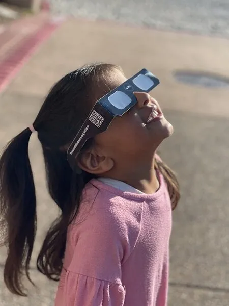 Girl wearing solar eclipse glasses