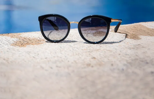 close up of a sunglasses next to a pool